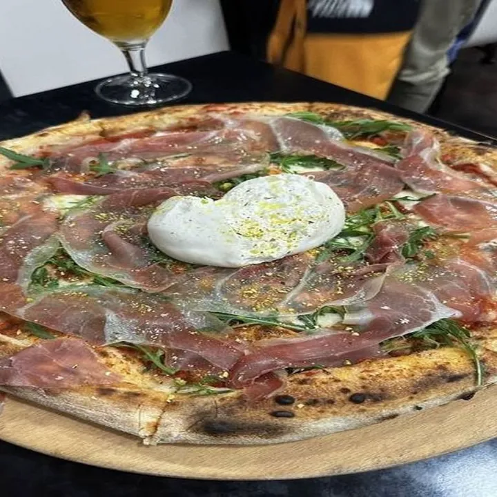 Pizza Burratina y Crudo servida en la mesa de Pizzería Nápoli